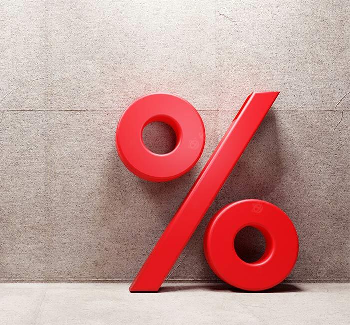 Czerwony znak procentu symbolizujący promocję, ustawiony na tle betonowej ściany